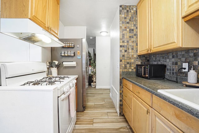 kitchen featuring light brown cabinets, gas range gas stove, and tasteful backsplash