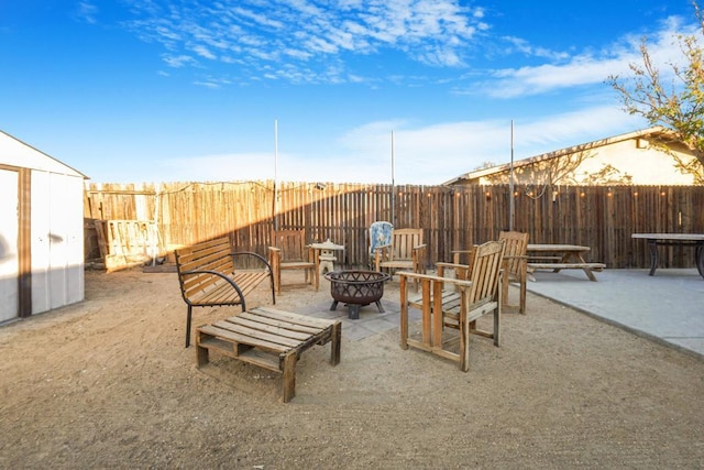 view of patio featuring an outdoor fire pit and a storage shed