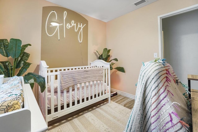 bedroom featuring a crib and hardwood / wood-style floors