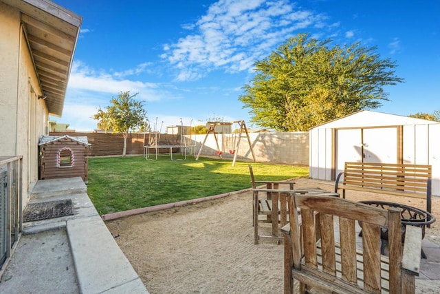 view of yard with a trampoline, a storage unit, a patio, and a playground