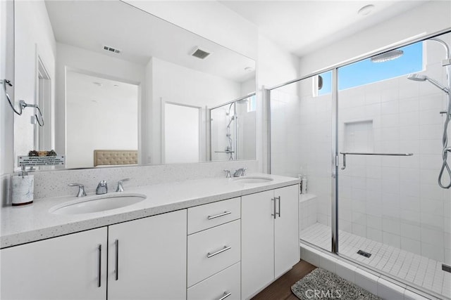 bathroom with a shower with door, wood-type flooring, and vanity