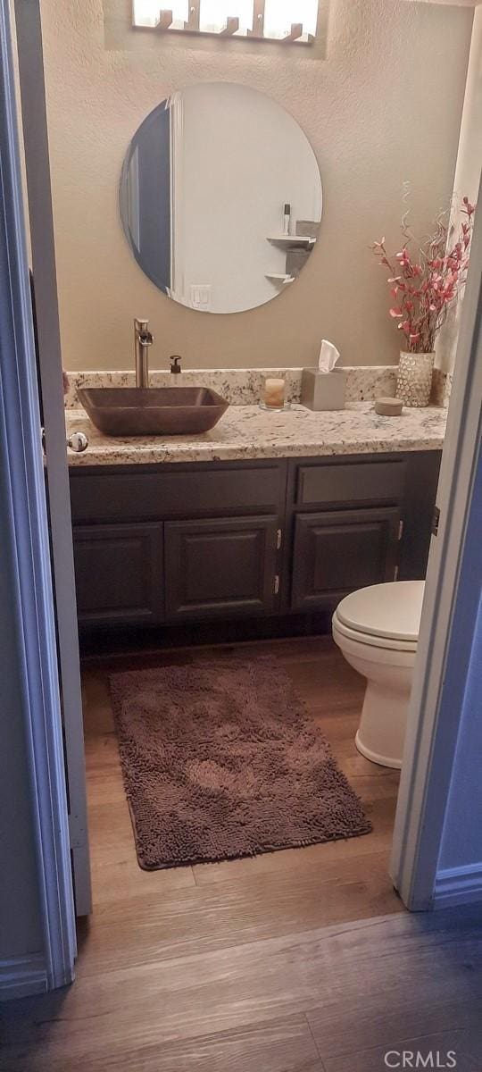 bathroom featuring vanity, hardwood / wood-style floors, and toilet