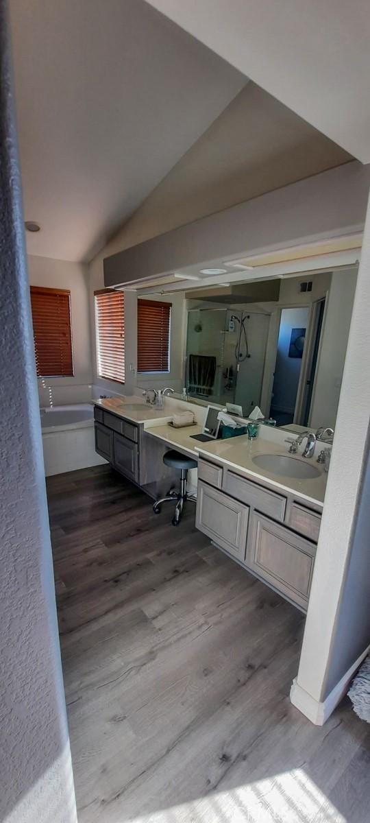 bathroom with hardwood / wood-style flooring, vanity, and vaulted ceiling