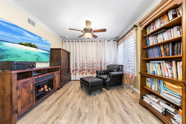 sitting room featuring ceiling fan, crown molding, and light hardwood / wood-style flooring