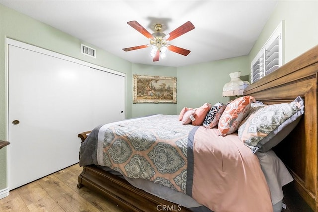 bedroom featuring ceiling fan, light hardwood / wood-style flooring, and a closet