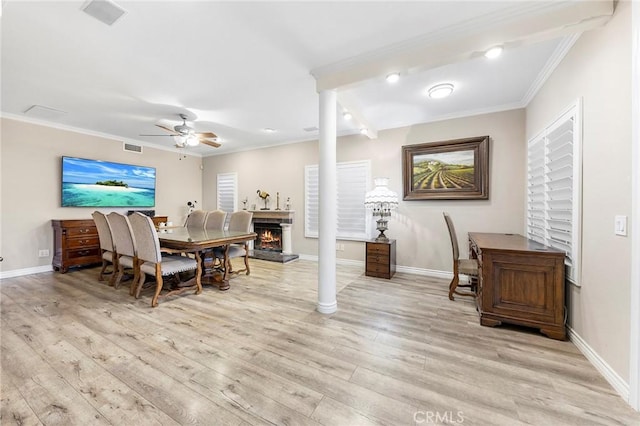 dining room with light wood-type flooring, ceiling fan, and crown molding