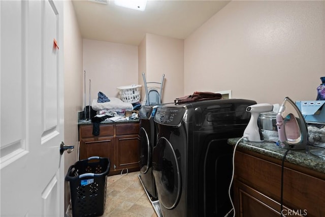 washroom with washing machine and dryer and cabinets