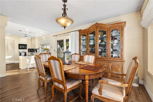 dining space featuring a textured ceiling, ceiling fan, and dark hardwood / wood-style floors