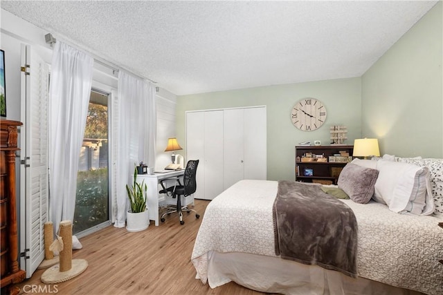 bedroom featuring light hardwood / wood-style floors, a textured ceiling, and a closet