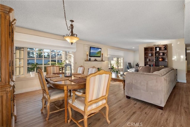 dining space with a textured ceiling and light hardwood / wood-style flooring