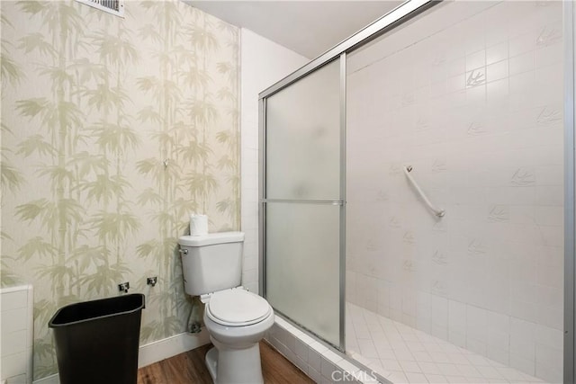 bathroom featuring toilet, hardwood / wood-style floors, and walk in shower