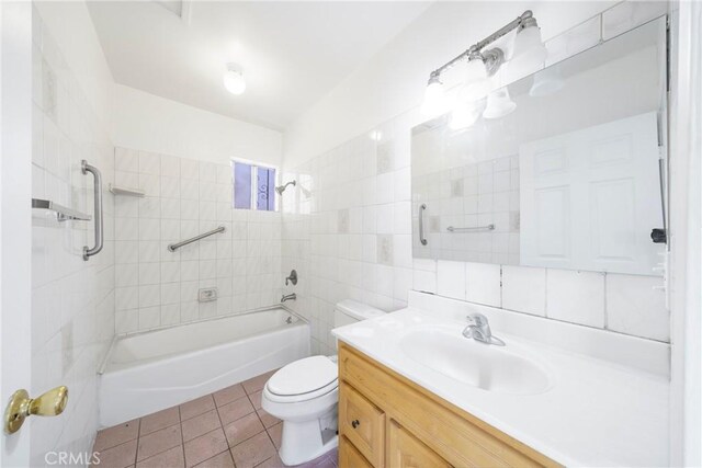 full bathroom with tiled shower / bath, tile patterned floors, vanity, decorative backsplash, and toilet