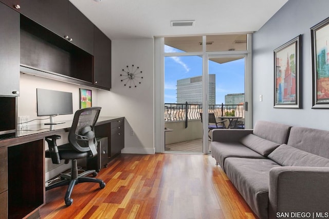 office featuring expansive windows and light wood-type flooring