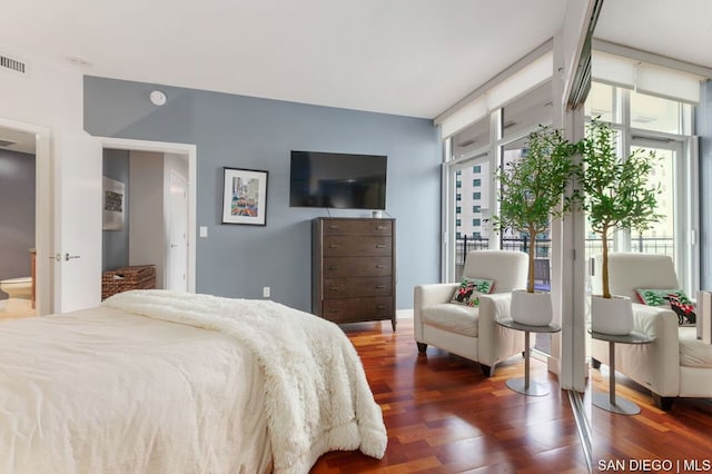 bedroom featuring connected bathroom and dark hardwood / wood-style floors