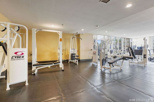 workout area with a textured ceiling and a wall of windows