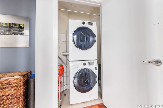 laundry room with tile patterned flooring and stacked washer and clothes dryer