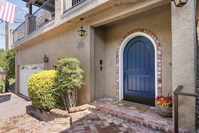 doorway to property with a balcony and a garage