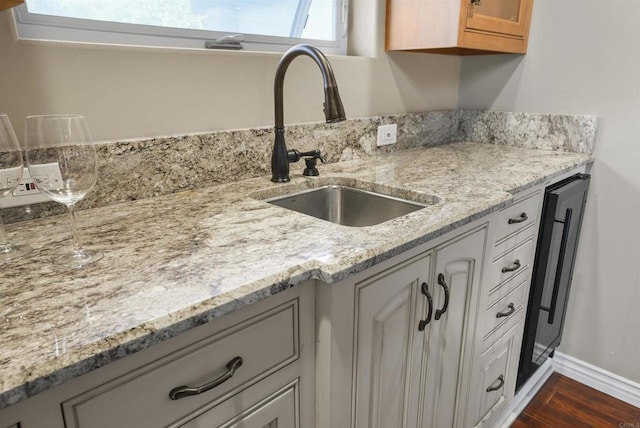 kitchen with dark hardwood / wood-style flooring, sink, and light stone counters