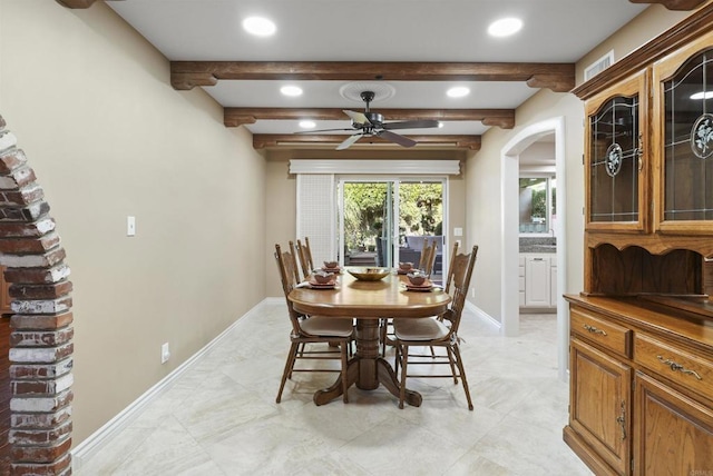 dining area featuring ceiling fan and beam ceiling