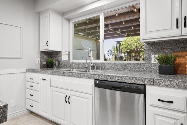 kitchen with dishwasher, sink, and white cabinetry