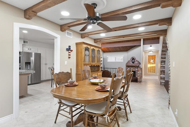 dining space with ceiling fan and beamed ceiling