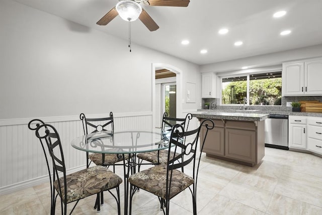 kitchen with white cabinetry, sink, ceiling fan, dishwasher, and decorative backsplash