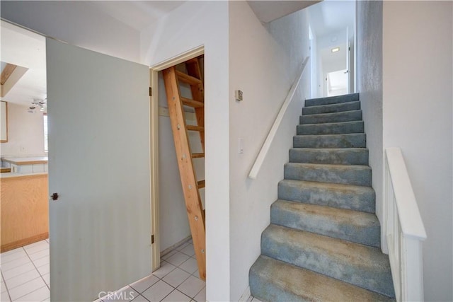 staircase featuring ceiling fan and tile patterned flooring