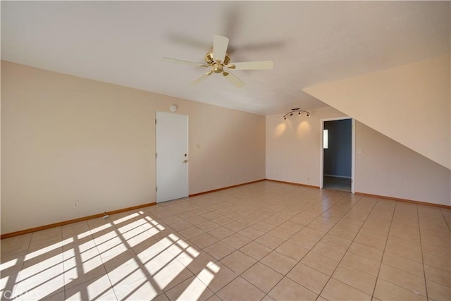 tiled spare room featuring ceiling fan and vaulted ceiling