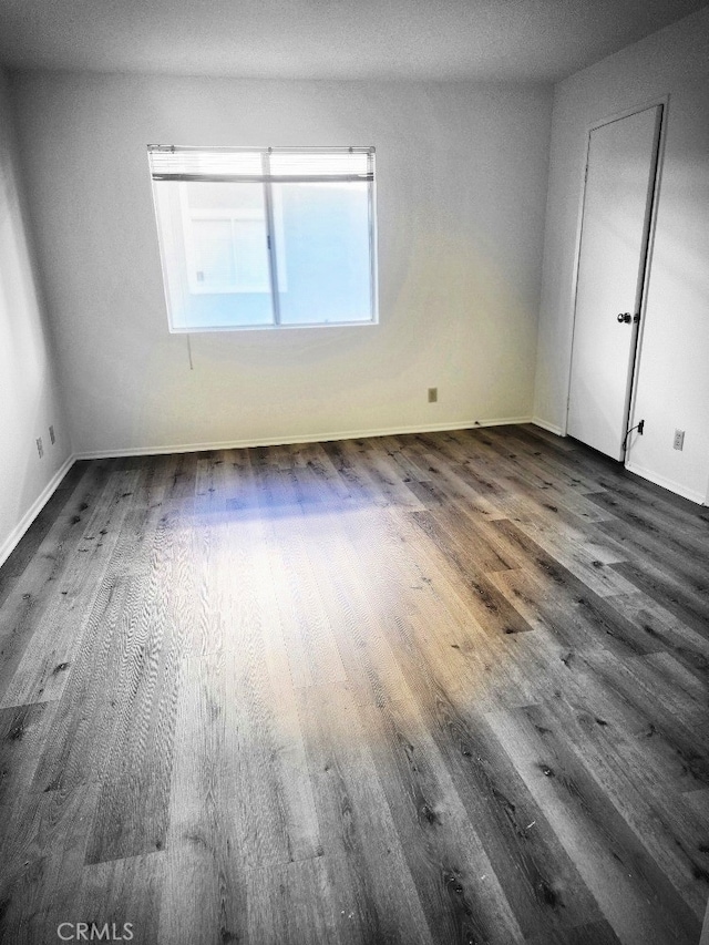 spare room with dark wood-type flooring