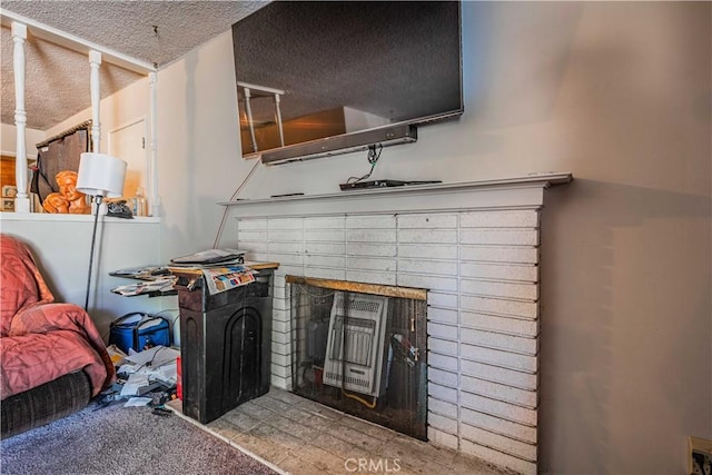 interior details featuring a fireplace, a textured ceiling, and carpet flooring