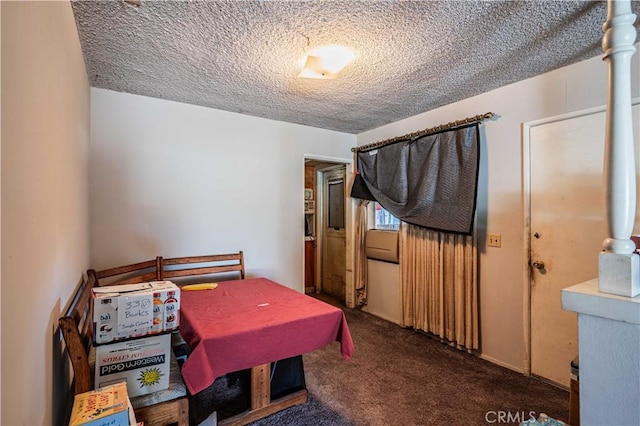 recreation room featuring a textured ceiling and dark colored carpet