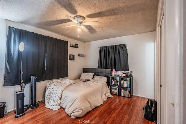 bedroom featuring ceiling fan, a textured ceiling, and hardwood / wood-style floors