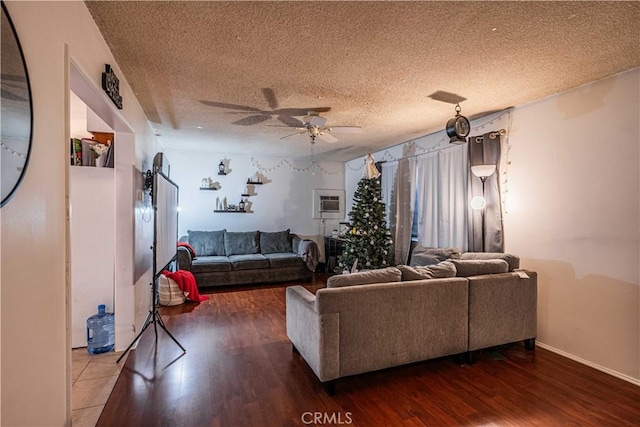 living room with ceiling fan, dark wood-type flooring, and a textured ceiling