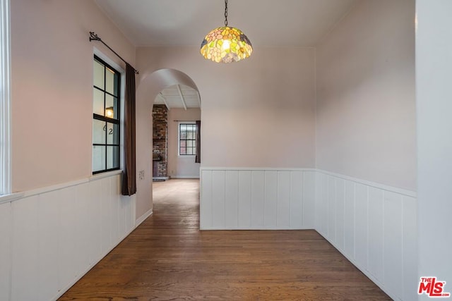 unfurnished dining area with dark wood-type flooring