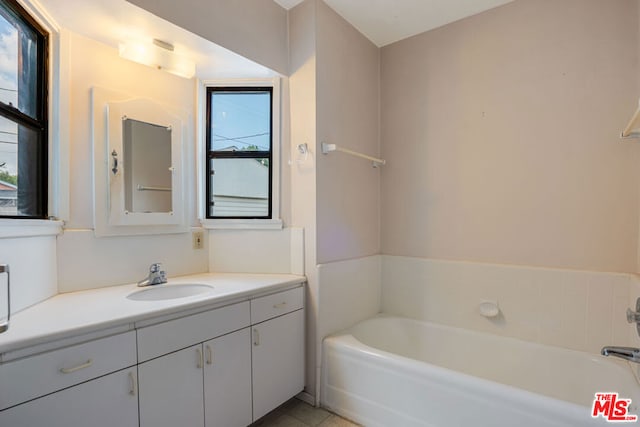 bathroom with a healthy amount of sunlight, vanity, and a washtub