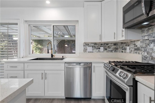 kitchen featuring appliances with stainless steel finishes, sink, and white cabinetry