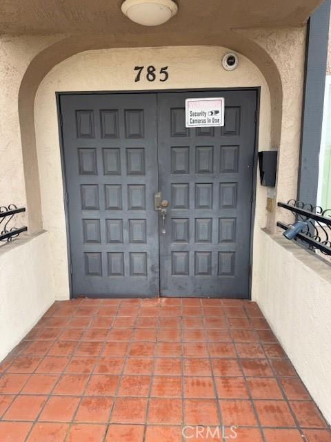 doorway to property featuring a garage and stucco siding