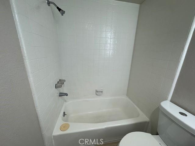 bathroom featuring toilet and washtub / shower combination