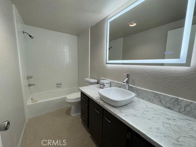 bathroom with tub / shower combination, vanity, and toilet