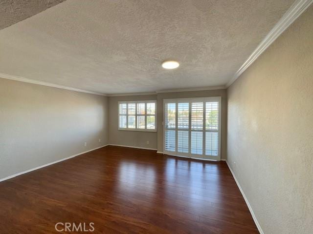 unfurnished room featuring crown molding, dark wood finished floors, a textured ceiling, and baseboards