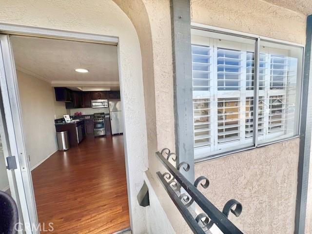 785 W 19th St Unit 12B, San Pedro, CA 90731 - workout room with dark wood-style flooring, a textured wall, crown molding, and arched walkways