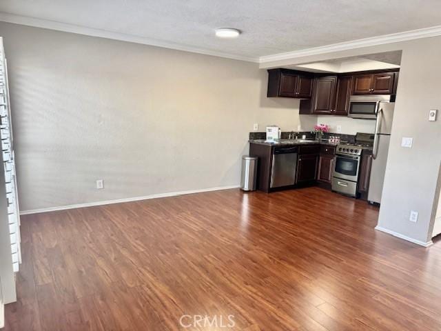 785 W 19th St Unit 12B, San Pedro, CA 90731 - kitchen featuring stainless steel appliances, dark wood finished floors, dark brown cabinets, ornamental molding, and dark countertops