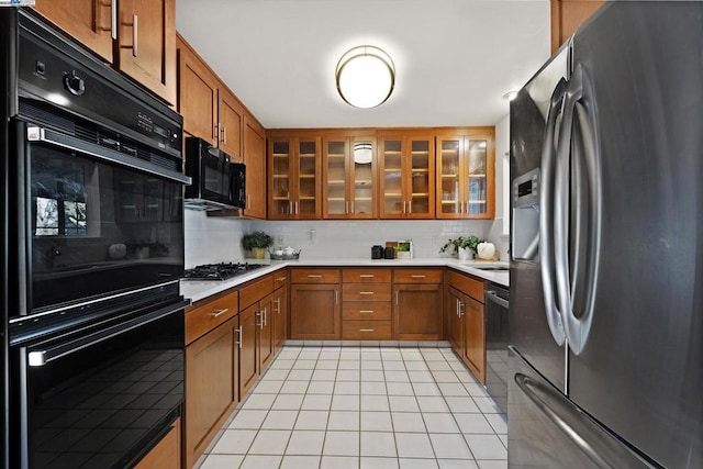 kitchen with light tile patterned floors, tasteful backsplash, and black appliances