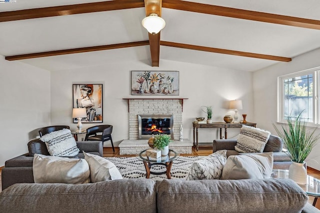 living room featuring lofted ceiling with beams, a fireplace, and hardwood / wood-style flooring