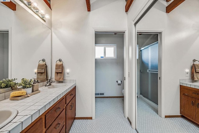 bathroom featuring beam ceiling, vanity, a shower with door, and toilet