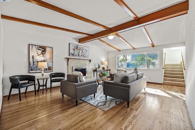 living room featuring lofted ceiling with beams, a fireplace, and hardwood / wood-style flooring