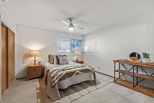 carpeted bedroom with ceiling fan and a closet