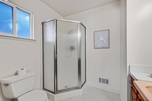 bathroom featuring toilet, walk in shower, tile patterned floors, and vanity