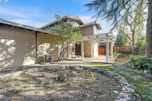 rear view of property with central air condition unit, a patio, and a pergola