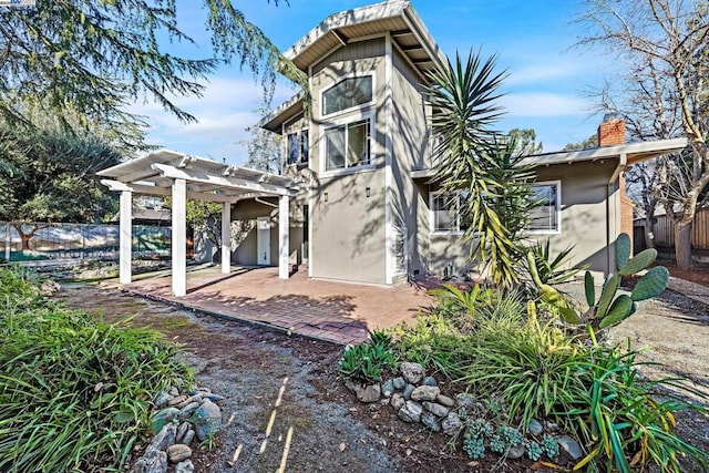 rear view of house featuring a pergola and a patio